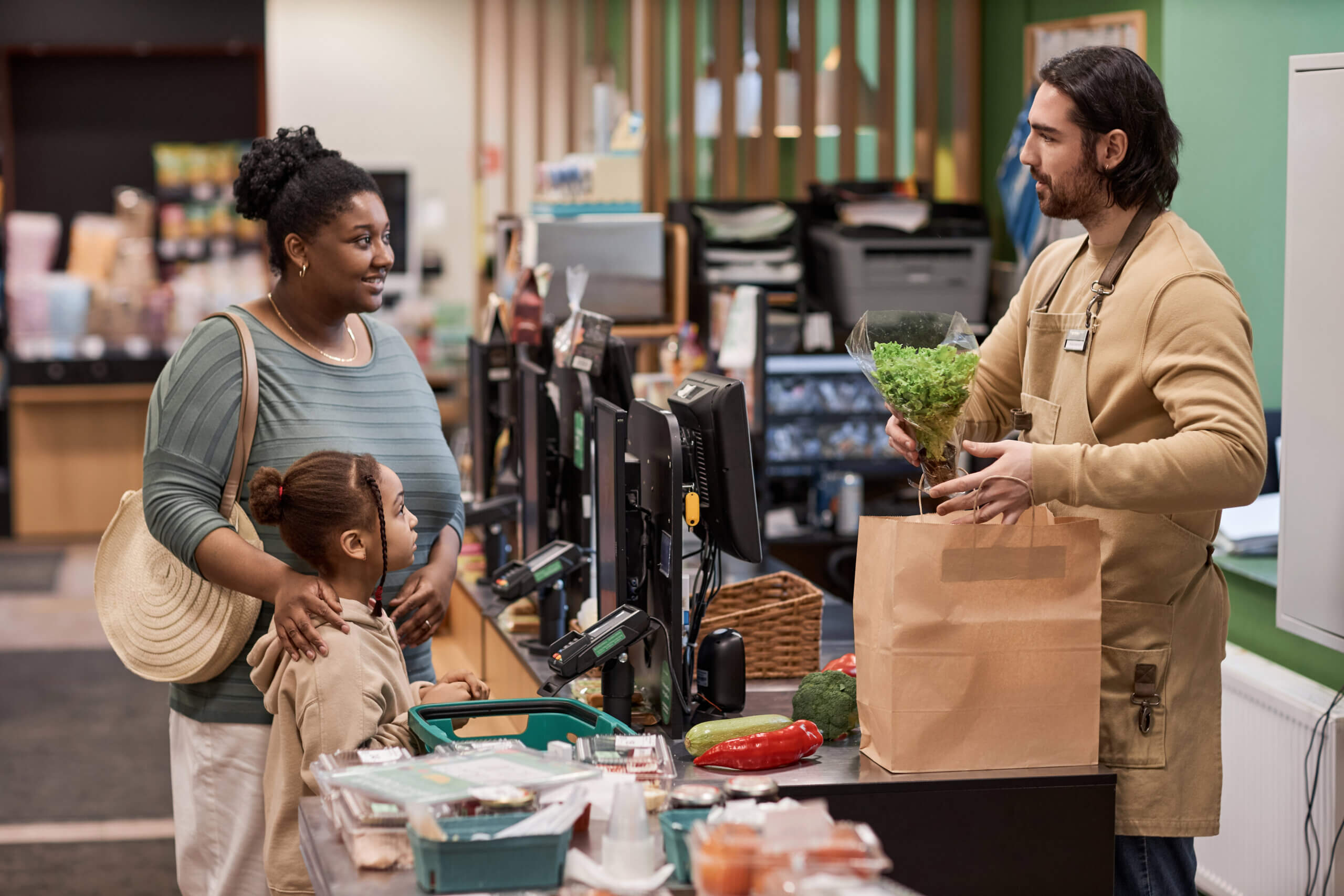 Side view portrait of black young mother with little girl buying groceries in supermarket
